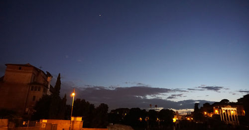 Low angle view of illuminated city against blue sky