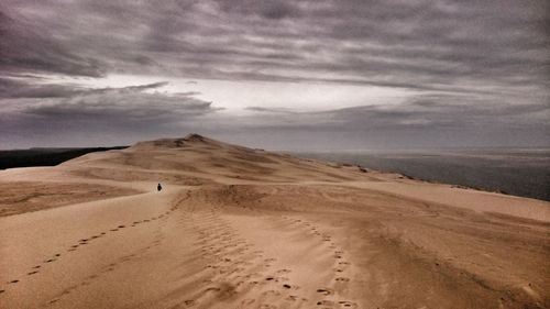 View of desert against cloudy sky