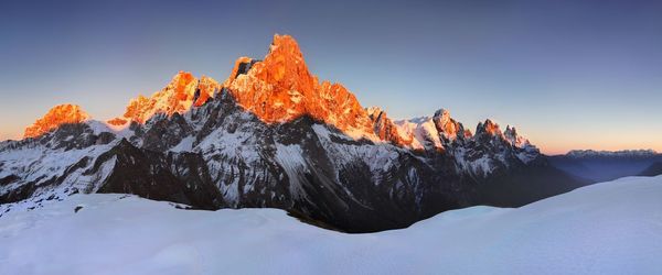 Scenic view of snowcapped mountains against clear sky during winter