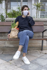 Full length of teenage girl sitting on bench