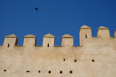 Low angle view of historical building against clear blue sky