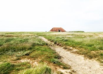 Scenic view of grassy field against sky