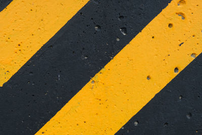 High angle view of yellow arrow symbol on road