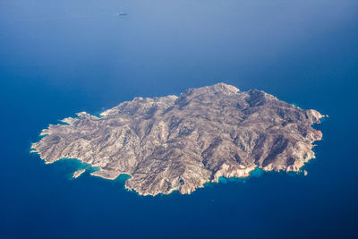 Aerial view of sea and mountain against blue sky