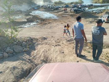 Rear view of people walking on shore