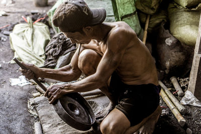 Side view of a young man sitting outdoors