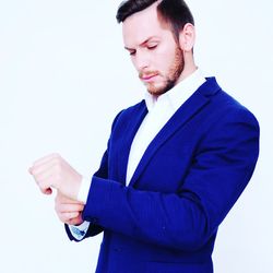 Portrait of young man standing against white background