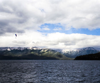 Scenic view of sea and snowcapped mountains against sky