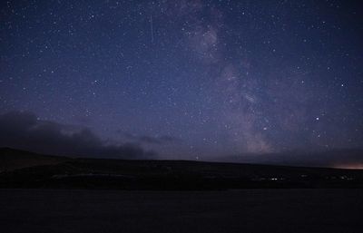 Scenic view of mountains against sky at night