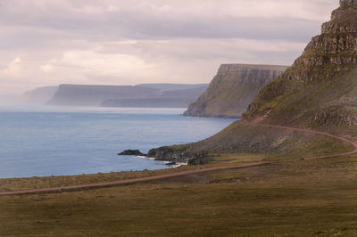 Scenic view of sea and mountains against sky