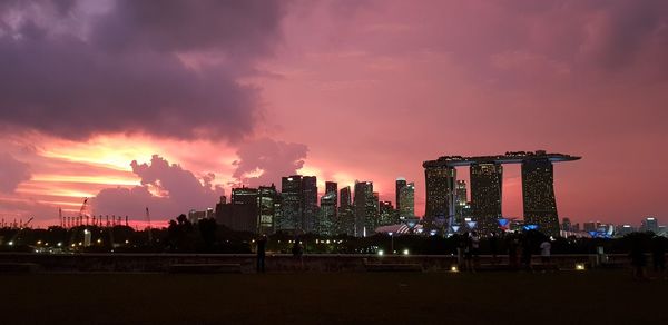 Illuminated cityscape against sky at night