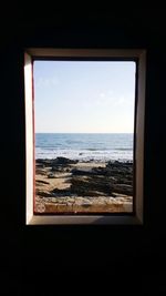 Close-up of sea against sky seen through window