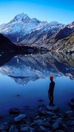 Rear view of man standing on snowcapped mountain