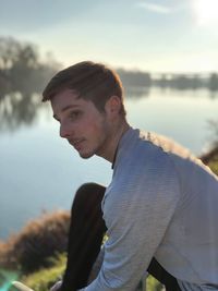 Portrait of young man looking at lake