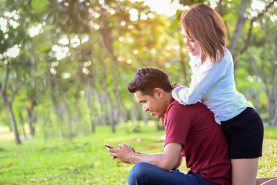 Side view of young man using mobile phone outdoors