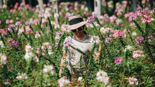 Woman with pink flowers on field