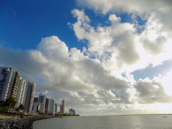 Scenic view of sea by buildings against sky