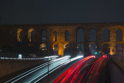 Light trails on road against sky at night