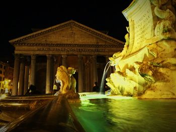 Statue of illuminated building at night