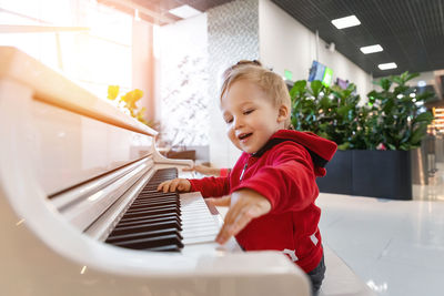 Happy boy playing in piano