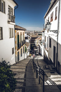 Footpath amidst buildings in city against clear sky