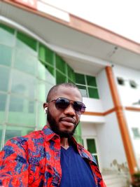 Portrait of young man wearing sunglasses standing outdoors