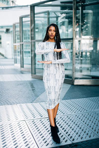 Portrait of beautiful young woman gesturing while standing on floor