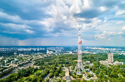 Aerial view of buildings in city against cloudy sky