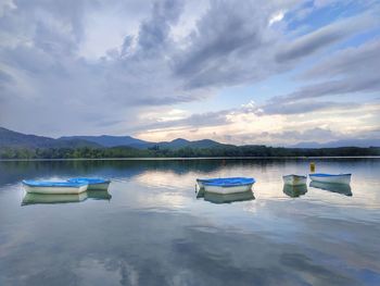 Boats moored in lake against sky