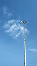 Low angle view of communications tower against blue sky