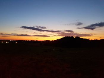 Scenic view of silhouette field against sky during sunset