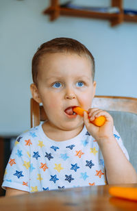 Portrait of cute boy eating food at home