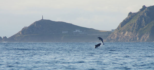 View of calm sea against mountain range