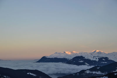 Scenic view of snowcapped mountains against sky during sunset