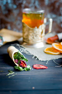 Green tea leaves with strawberry in a wooden spoon