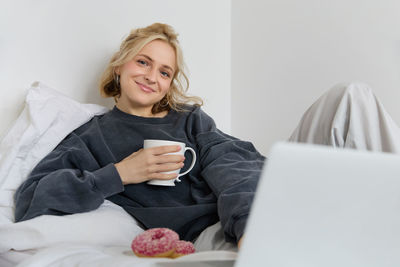 Portrait of young woman using laptop at home