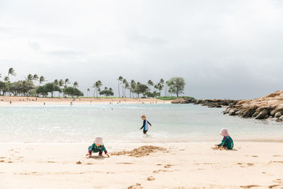 Toddlers playing pin the beach in hawaii