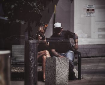 People sitting on seat in front of building