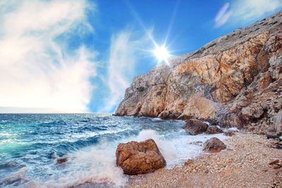 Rocks on beach against sky