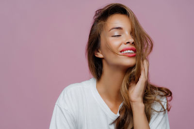 Portrait of young woman against wall