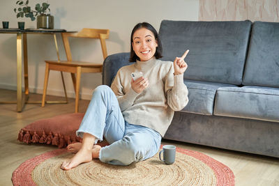 Portrait of young woman sitting at home