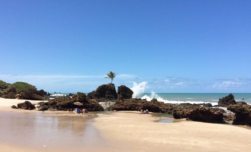 Scenic view of beach against clear blue sky