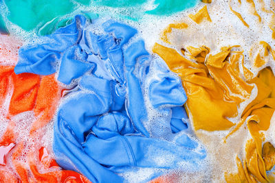 Full frame shot of multi colored textiles in water with soap sud