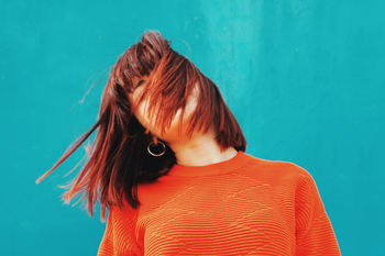 Woman with tousled hair against wall