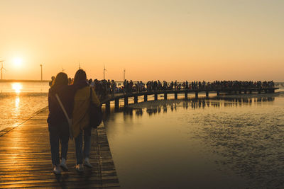 Rear view of couple at beach during sunset