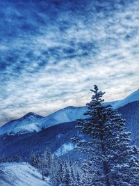 Snow covered mountains against cloudy sky