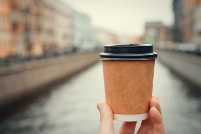 Close-up of hand holding coffee cup