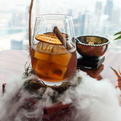 Close-up of drink over smoke at table