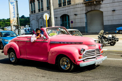 Vintage car on street against buildings in city