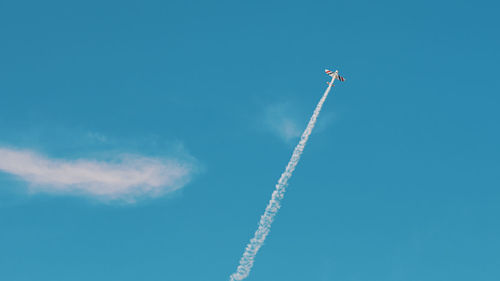 Low angle view of vapor trail against blue sky